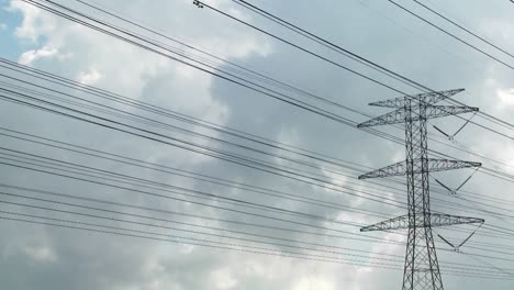 Zeitraffer-Von-Wolken,-Die-Sich-Hinter-Hochspannungsdrähten-Und-Stromleitungen-Bewegen