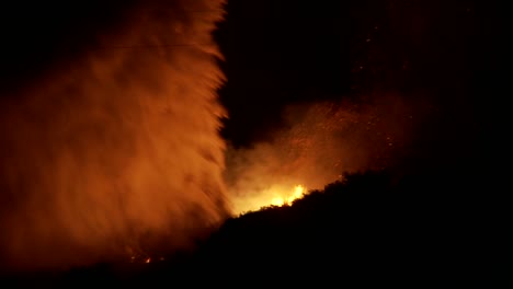 Firefighters-battle-a-raging-California-wildfire-at-night-by-performing-a-water-drop-from-an-vista-aérea-tanker-1