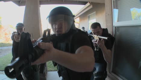 DEA-or-SWAT-officers-with-arms-drawn-pound-on-the-door-before-performing-a-drug-raid-on-a-house