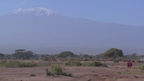 Masai-warriors-walk-in-in-front-of-Mt-Kilimanjaro-in-Tanzania-East-Africa