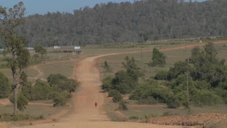 Ein-Mann-Geht-In-Der-Ferne-Auf-Einem-Einsamen-Staubigen-Feldweg-In-Afrika