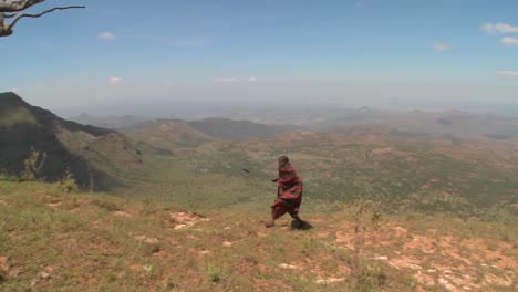 Ein-Massai-Krieger,-Der-Durch-Eine-Weite-Landschaft-In-Nordkenia-Geht