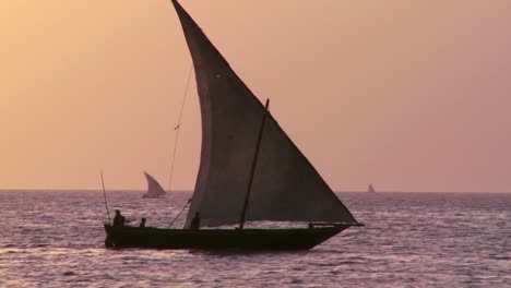 Eine-Schöne-Aufnahme-Eines-Dhow-Segelboots,-Das-Bei-Sonnenuntergang-In-Sansibar-Segelt?