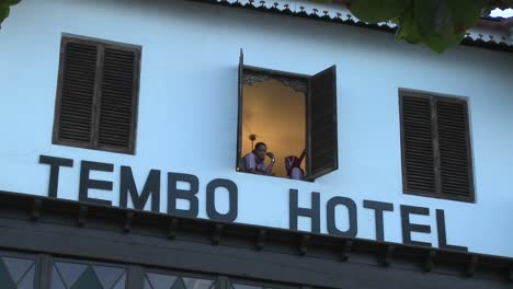 Zwei-Mädchen-Schauen-Aus-Einem-Tropischen-Strandhotelfenster