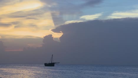 Ein-Fernes-Boot-Fährt-Bei-Sonnenaufgang-Entlang-Der-Küste-Von-Sansibar
