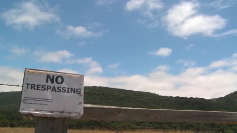 Time-lapse-of-clouds-drifting-past-a-no-trespassing-sign