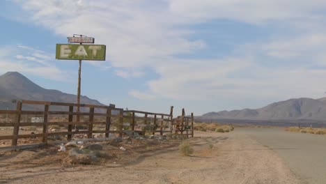 Ein-Langsamer-Zoom-In-Ein-Verlassenes-Restaurant-Mit-Einem-Schild-Mit-Der-Aufschrift-&quot;Essen-In-Der-Mojave-Wüste&quot;