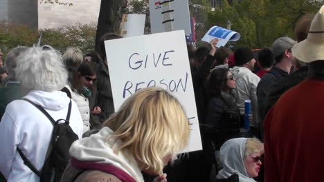 Protestors-hold-signs-at-a-rally-including-give-reason-a-chance