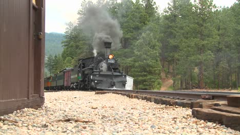 In-Dieser-Klassischen-Western-Aufnahme-Fahren-Wir-Mit-Einem-Dampfzug-Nach-Oben,-Der-An-Einem-Depot-Vorbeifährt