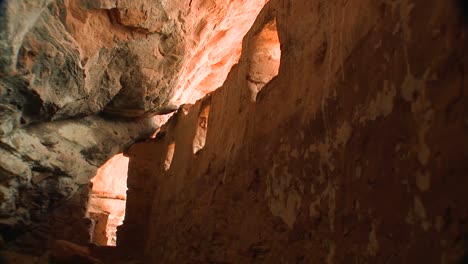 A-woman-walks-through-an-ancient-Native-American-Indian-cliff-dwelling