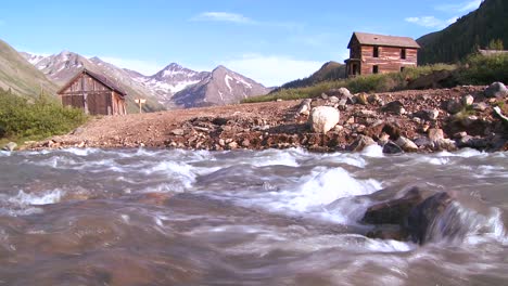 Traveling-shot-along-a-river-with-Colorado-ghost-town-background