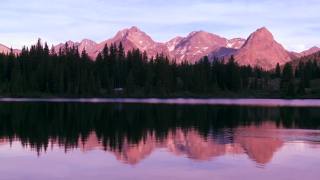 The-Rocky-Mountains-are-perfectly-reflected-in-an-alpine-lake-at-sunset