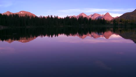 The-Rocky-Mountains-are-perfectly-reflected-in-an-alpine-lake-at-sunset-or-dawn-in-this-traveing-shot-2