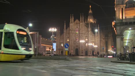 Un-Tranvía-Pasa-Por-La-Noche-En-Una-Calle-Frente-A-La-Catedral-Del-Duomo-De-Milán-Italia