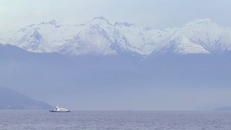 Ein-Kleines-Boot-überquert-Einen-See-Vor-Den-Alpen-In-Italien-Oder-Schweiz