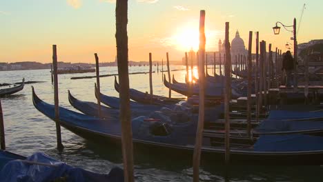 A-beautiful-shot-of-the-sun-setting-behind-rows-of-gondolas-in-Venice-Italy