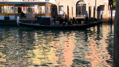 A-gondola-is-rowed-across-beautiful-colorful-water-in-Venice-Italy-1