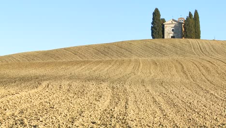 A-shot-across-Tuscany-Italy-fields-to-a-distant-farm-house-or-church