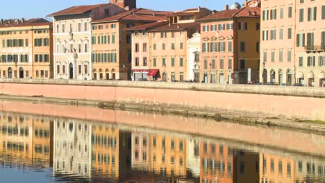 Buildings-line-and-are-reflected-in-a-symmetrical-canal-in-Pisa-Italy-3