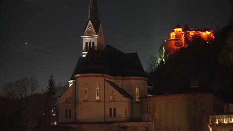 A-church-and-distant-medieval-castle-at-night-at-Lake-Bled-Slovenia