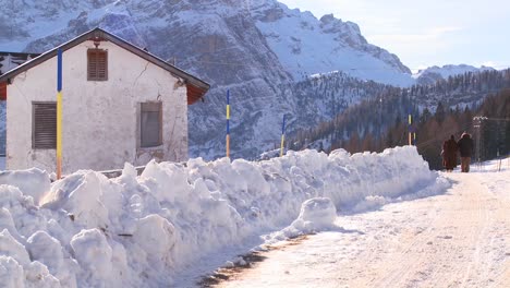 Una-Pareja-De-Ancianos-Camina-Por-Una-Carretera-Cubierta-De-Nieve-En-Los-Alpes-Suizos