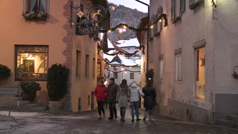 People-walk-in-a-snowbound-Tyrolean-village-in-the-Alps-in-Austria-Switzerland-Italy-Slovenia-or-an-Eastern-European-country