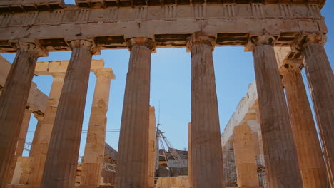 Low-angle-pan-of-the-columns-of-the-Acropolis-and-Parthenon-on-the-hilltop-in-Athens-Greece-1