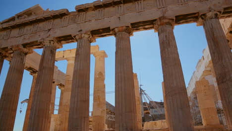 Low-angle-pan-of-the-columns-of-the-Acropolis-and-Parthenon-on-the-hilltop-in-Athens-Greece-2