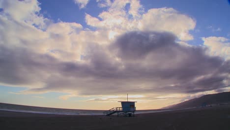 Time-lapse-of-a-cloud-formations-moving-behind-a-lifeguard-station-on-a-Los-Angeles-beach
