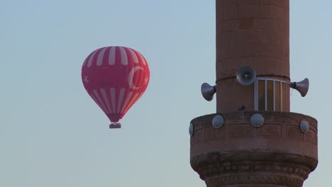 Die-Türkische-Flagge-Wird-Auf-Einem-Heißluftballon-Angezeigt,-Wenn-Er-An-Einer-Moschee-In-Kappadokien-Türkei-Vorbeifliegt