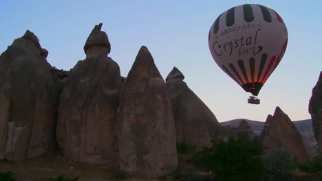 A-hot-air-balloon-flies-over-the-magnificent-geological-formations-of-Cappadocia-Turkey