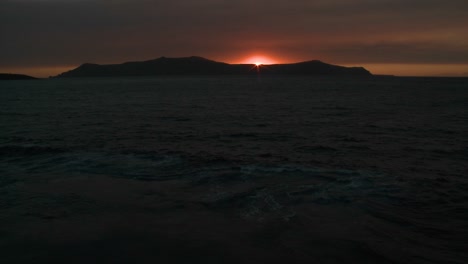 The-sun-sets-behind-an-island-in-the-ocean-1