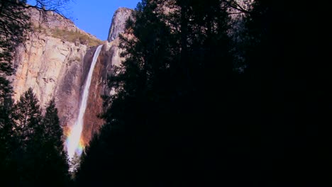Schwenken-Sie-über-Einen-Wunderschönen-Wasserfall-Im-Yosemite-Nationalpark,-Während-Er-Einen-Regenbogen-Wirft