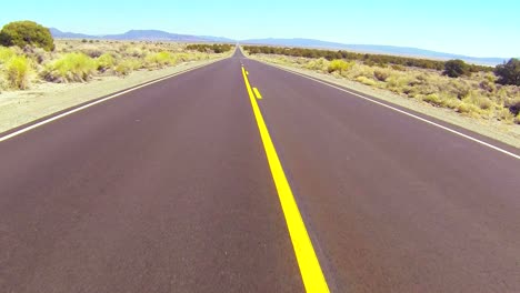 POV-shot-conduciendo-along-a-desert-road-at-a-fast-speed