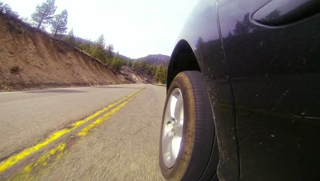 POV-shot-driving-along-a-highway-with-side-of-car-and-wheel-visible