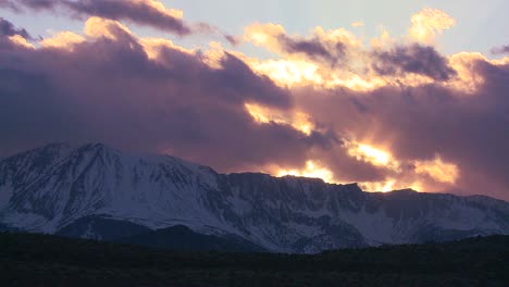 Time-lapse-of-the-snowcapped-Sierra-Nevada-mountains-with-the-sun-shining-through-clouds