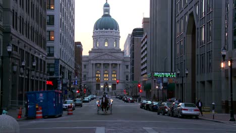 A-horse-drawn-carriage-passes-the-downtown-capital-building-in-Indianapolis-Indiana