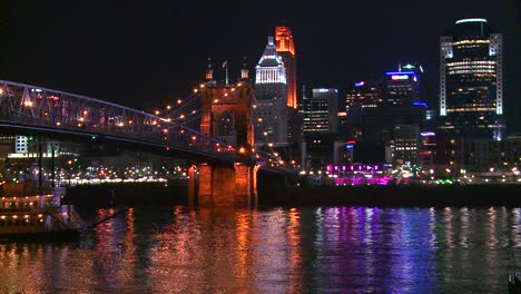 Licht-Reflektiert-Vom-Ohio-River-Mit-Dem-Hintergrund-Der-Stadt-Cincinnati-Ohio,-Während-Ein-Flussboot-Darunter-Vorbeifährt