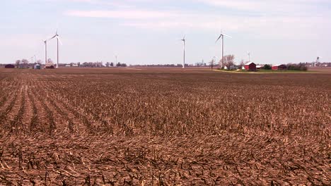 Giant-windmills-in-the-distance-generate-power-behind-farms-in-the-American-midwest