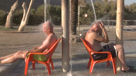 Menschen-Baden-Unter-Einer-Dusche-Mit-Heißem-Salzwasser-Am-Toten-Meer-In-Israel