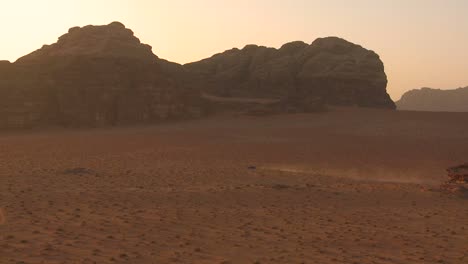 Eine-Staubspur-Folgt-Einem-Fahrzeug-Durch-Die-Wüste-Im-Wadi-Rum-Jordan