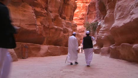 Arab-men-walk-through-the-narrow-canyons-leading-up-to-Petra-Jordan