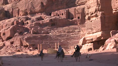 La-Gente-Monta-Burros-Cerca-Del-Antiguo-Anfiteatro-En-Las-Antiguas-Ruinas-Nabateas-De-Petra,-Jordania