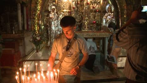 Un-Joven-Enciende-Una-Vela-En-El-Santo-Sepulcro-En-Jerusalén-ISRAEL