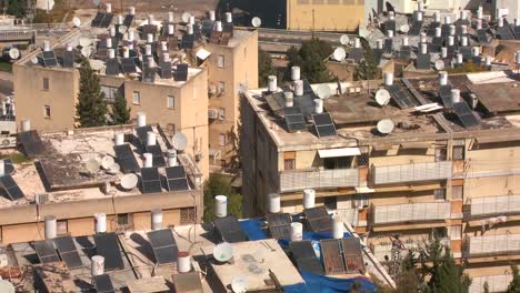Establishing-shot-overlooking-apartments-and-buildings-in-Haifa-Israel-with-solar-panels-and-water-heaters-on-rooftops