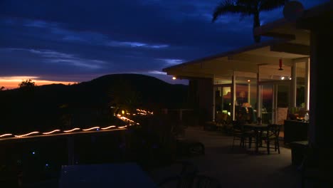 Panning-shot-of-the-deck-of-a-hillside-home-at-twilight