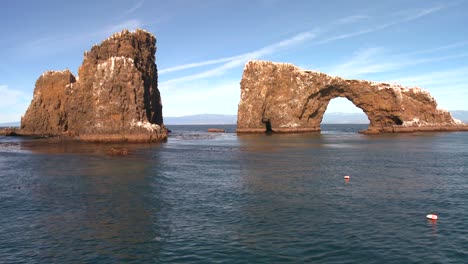Anacapa-Islands-iconic-natural-bridge-and-nearby-islets-in-Channel-Islands-National-Park-as-seen-from-a-boat-just-offshore