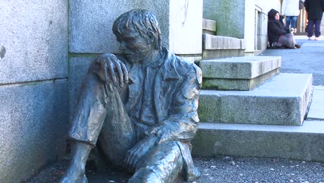 Ein-Obdachloser-Sitzt-In-Der-Nähe-Einer-Statue,-Die-Einen-Obdachlosen-Auf-Den-Straßen-Norwegens-Darstellt-1