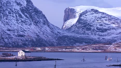 A-fishing-boat-heads-through-fjords-in-golden-light-in-the-Arctic-Lofoten-Islands-Norway