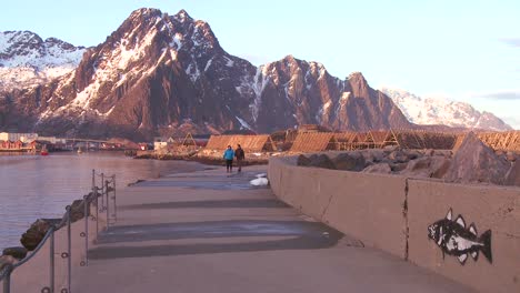 People-walk-along-a-dock-north-of-the-Arctic-Circle-in-Lofoten-Islands-Norway